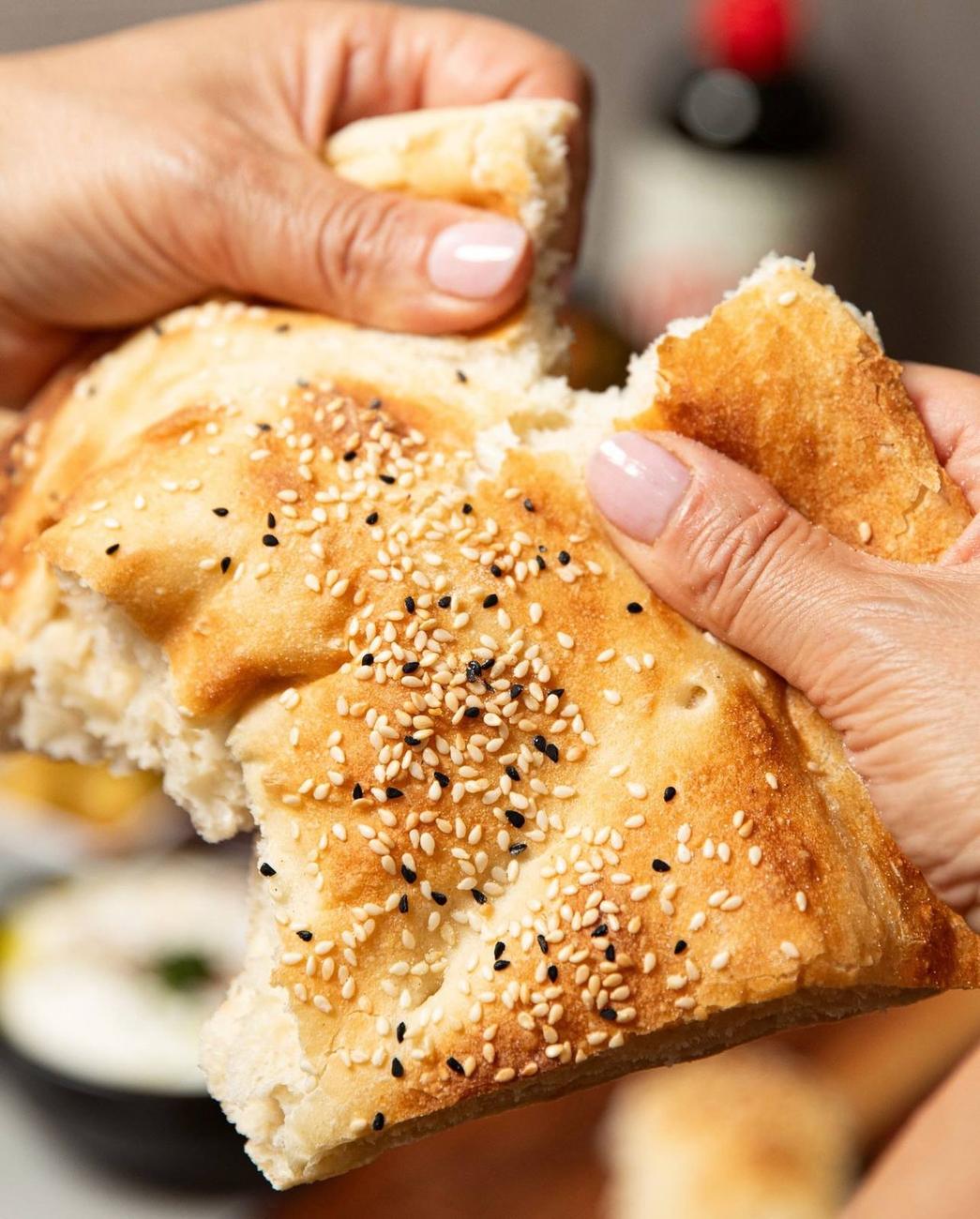 Tearing a fresh loaf of Turkish bread