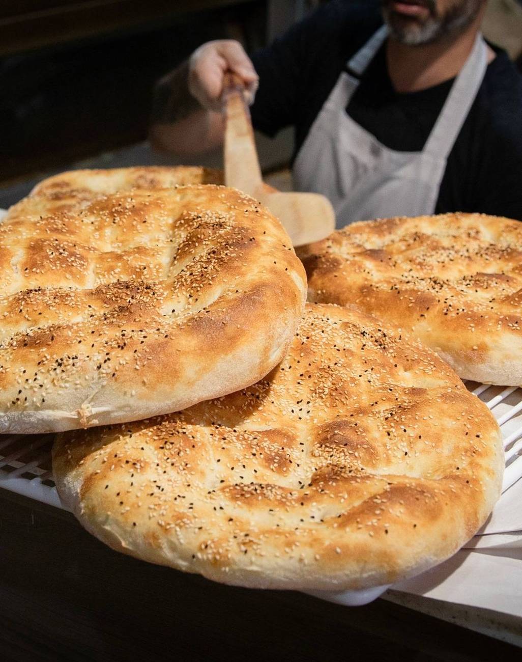 Turkish bread coming out of the oven on the peel