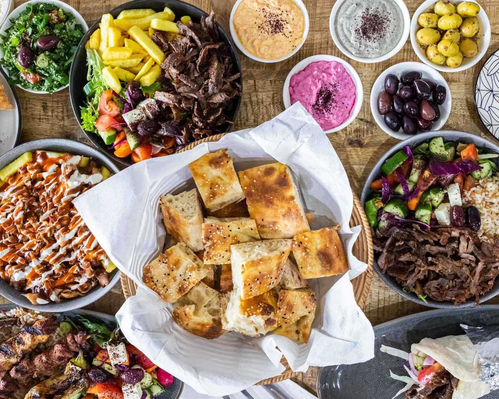 A spread of Marmaris Turkish bread, dips, doner, salads and chips