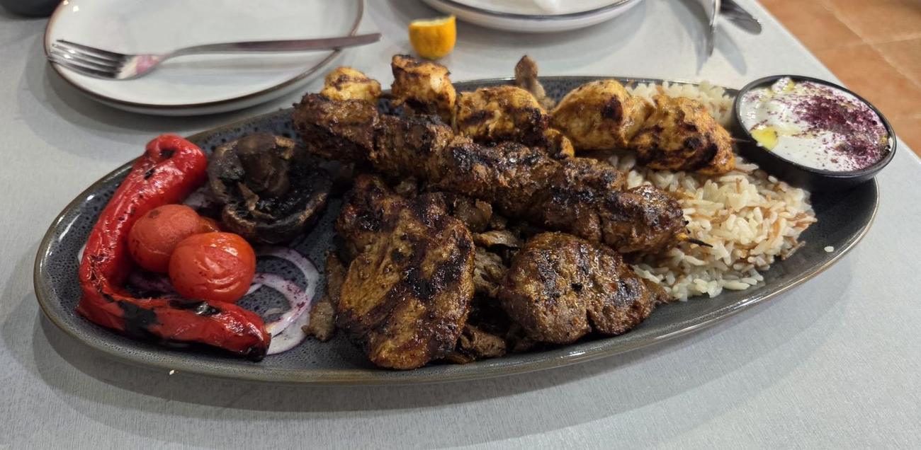 Mixed grill with rice, grilled tomato and capsicum